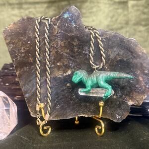 Upcycled vintage dinosaur necklace with clear quartz on gold chain.